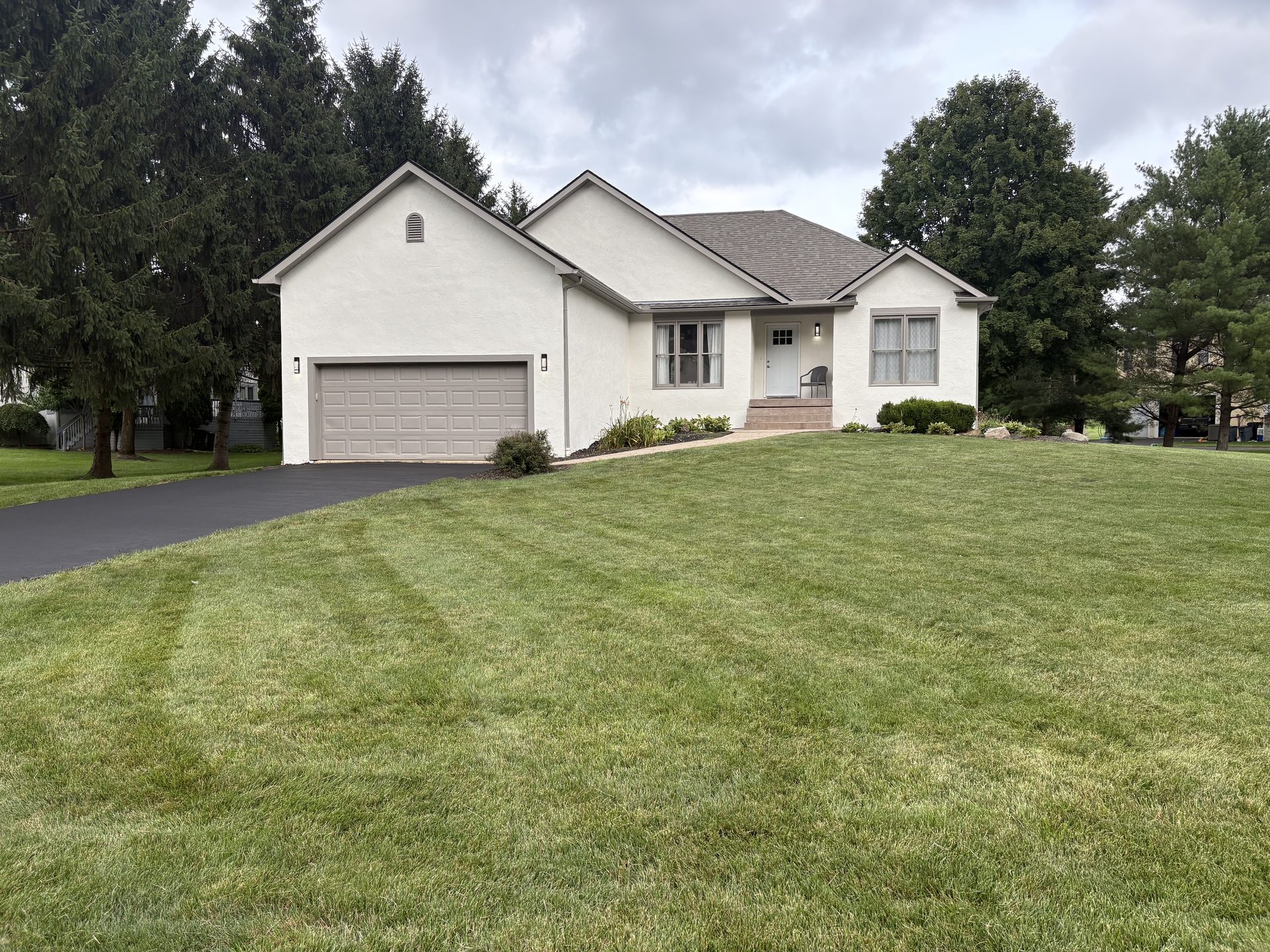 Completed exterior stucco repaint, rear view, Galena OH